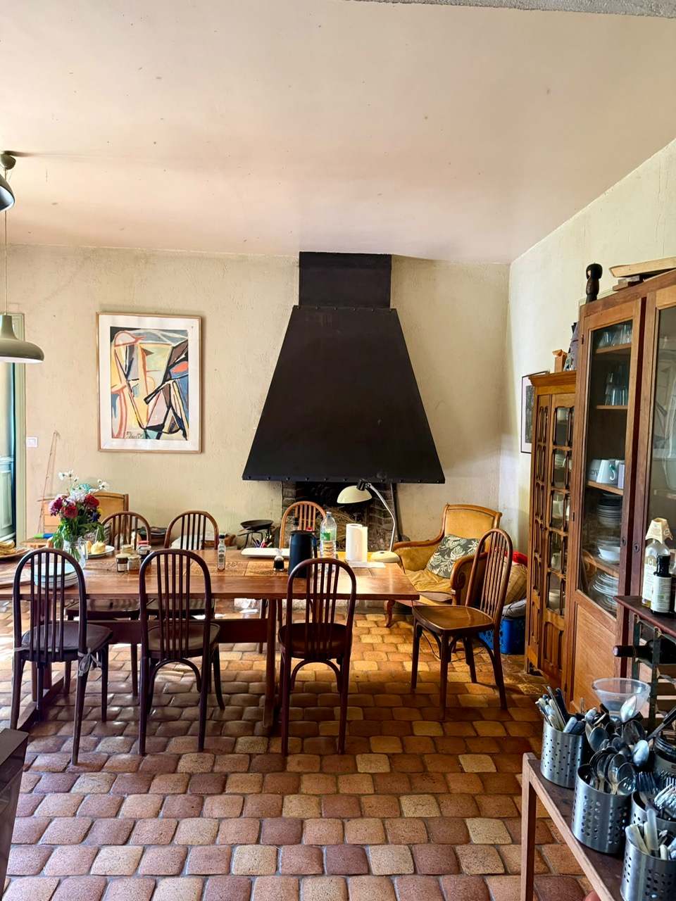 La cuisine avec sa grande table, sa cheminée et le vaisselier