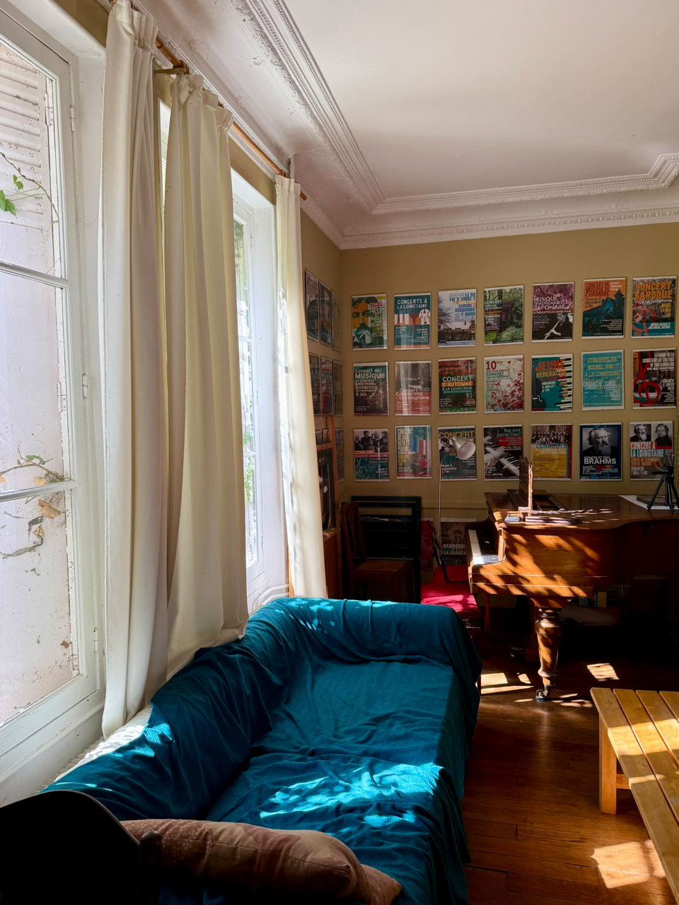 Le salon-salle à manger avec son piano, ses affiches de concerts et la lumière des fenêtres