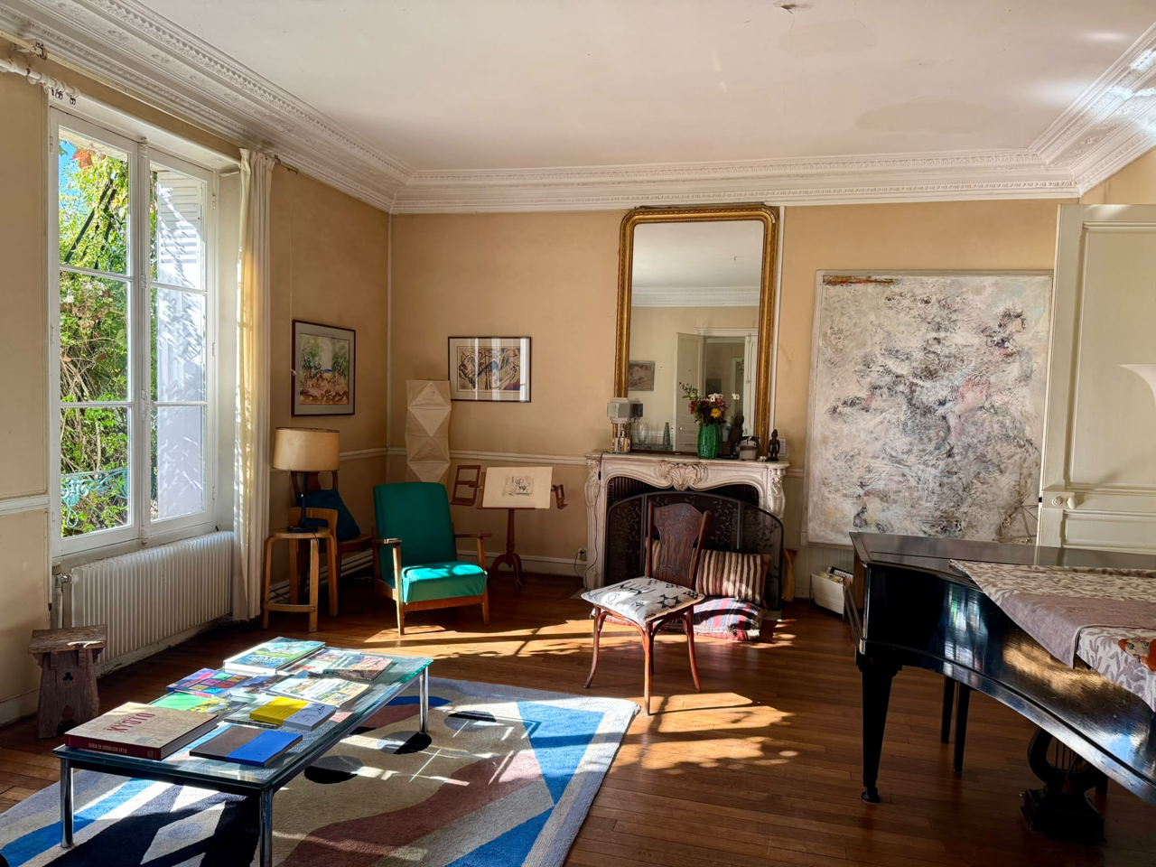 Le salon-salle à manger avec son piano à queue Pleyel, la cheminée et le grand miroir